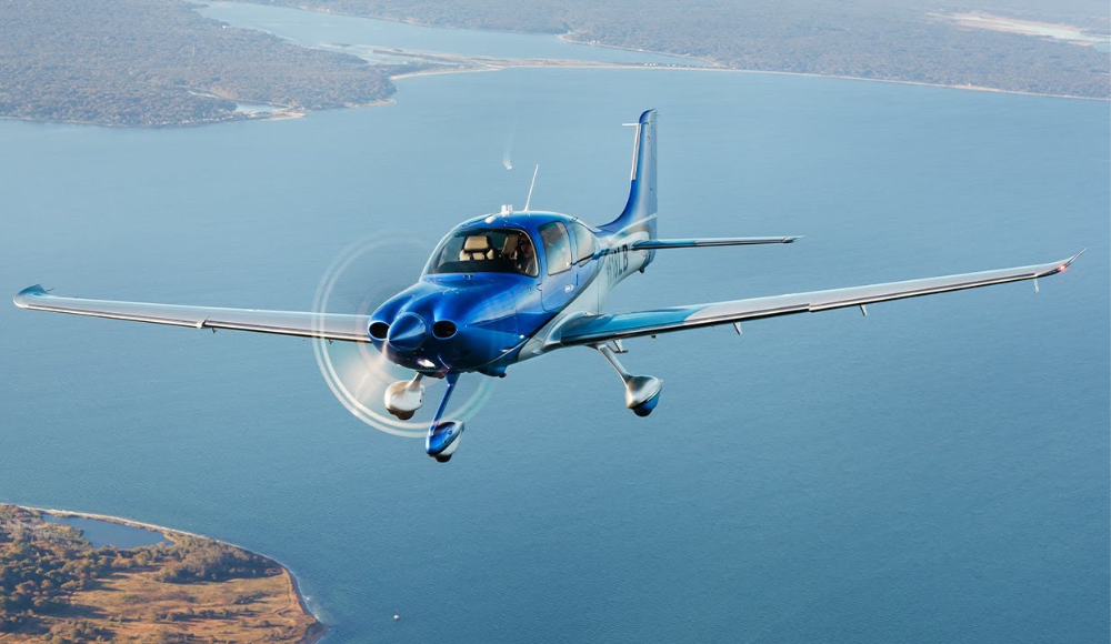 Cirrus SR22T in flight, demonstrating its advanced performance and long-range capabilities above scenic waters.